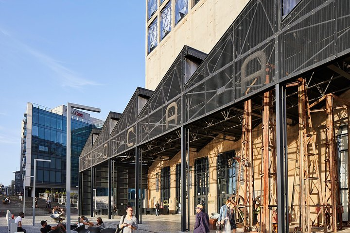 Experience the unique fusion of contemporary art and African heritage at Zeitz MOCAA where diverse visitors gather amid striking architecture and a rich cultural journey awaits.